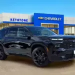 Black Chevrolet SUV parked in front of Keystone Chevrolet dealership with blue signage visible